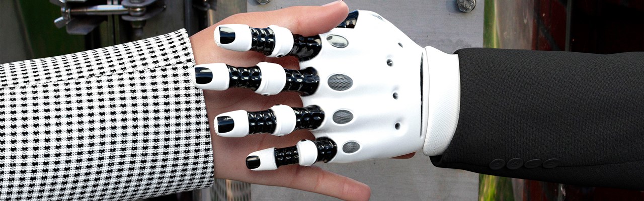 Närbild på robothand skakar hand med en människa.