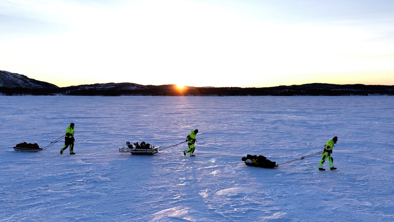 Three researchers walking over a frozen fjord in the documentary "Fjords Frontiers: Digging into the future of climate change".