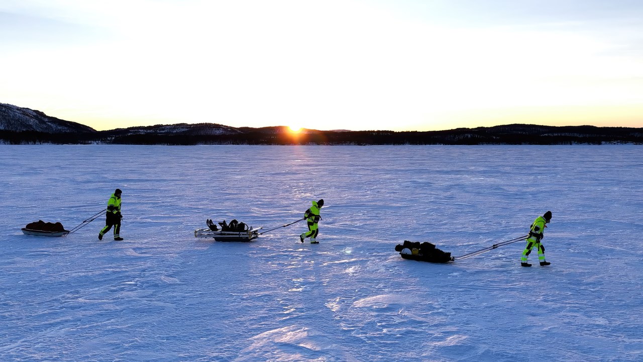 Three researchers walking over a frozen fjord in the documentary "Fjords Frontiers: Digging into the future of climate change".