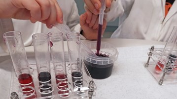 Barn gör experiment med pH-indikatorn rödkål